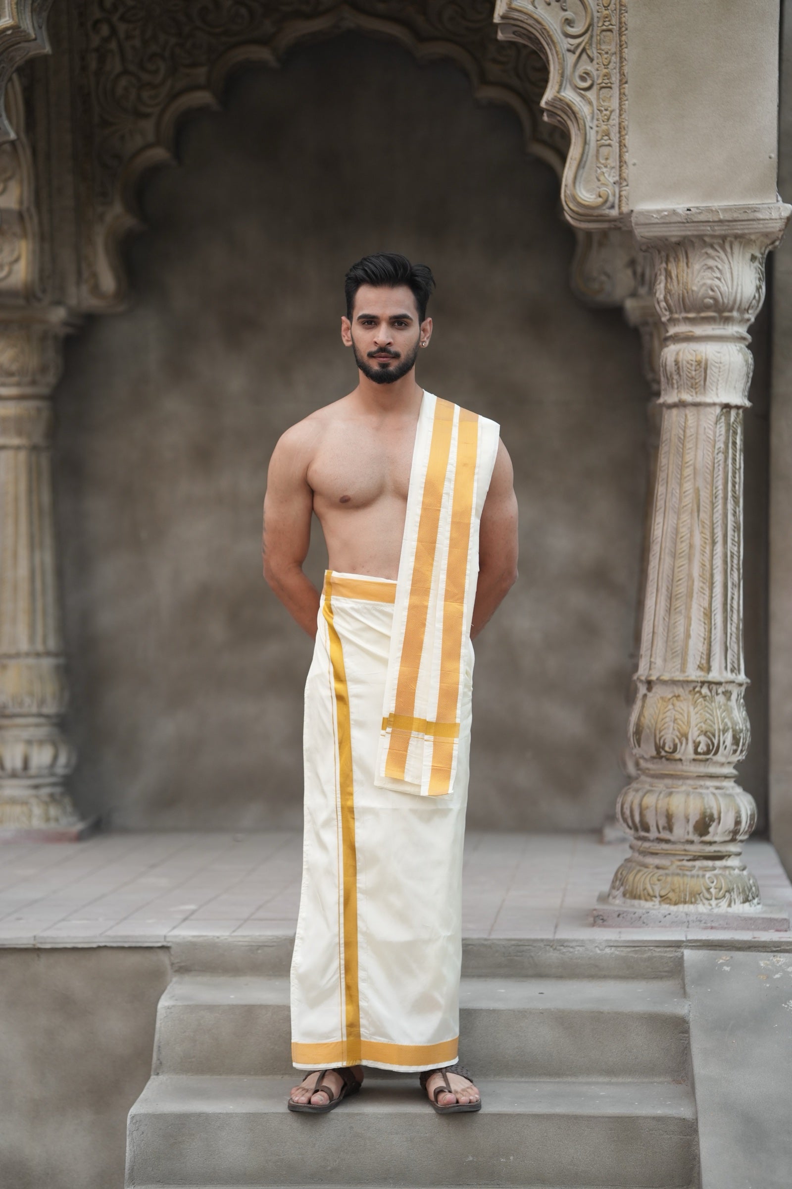 Man wearing a 2 inch golden border white artificial silk dhoti with gamcha