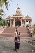 Man in traditional attire standing in front of a temple