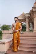 Man wearing a orange dhoti with matching uparana