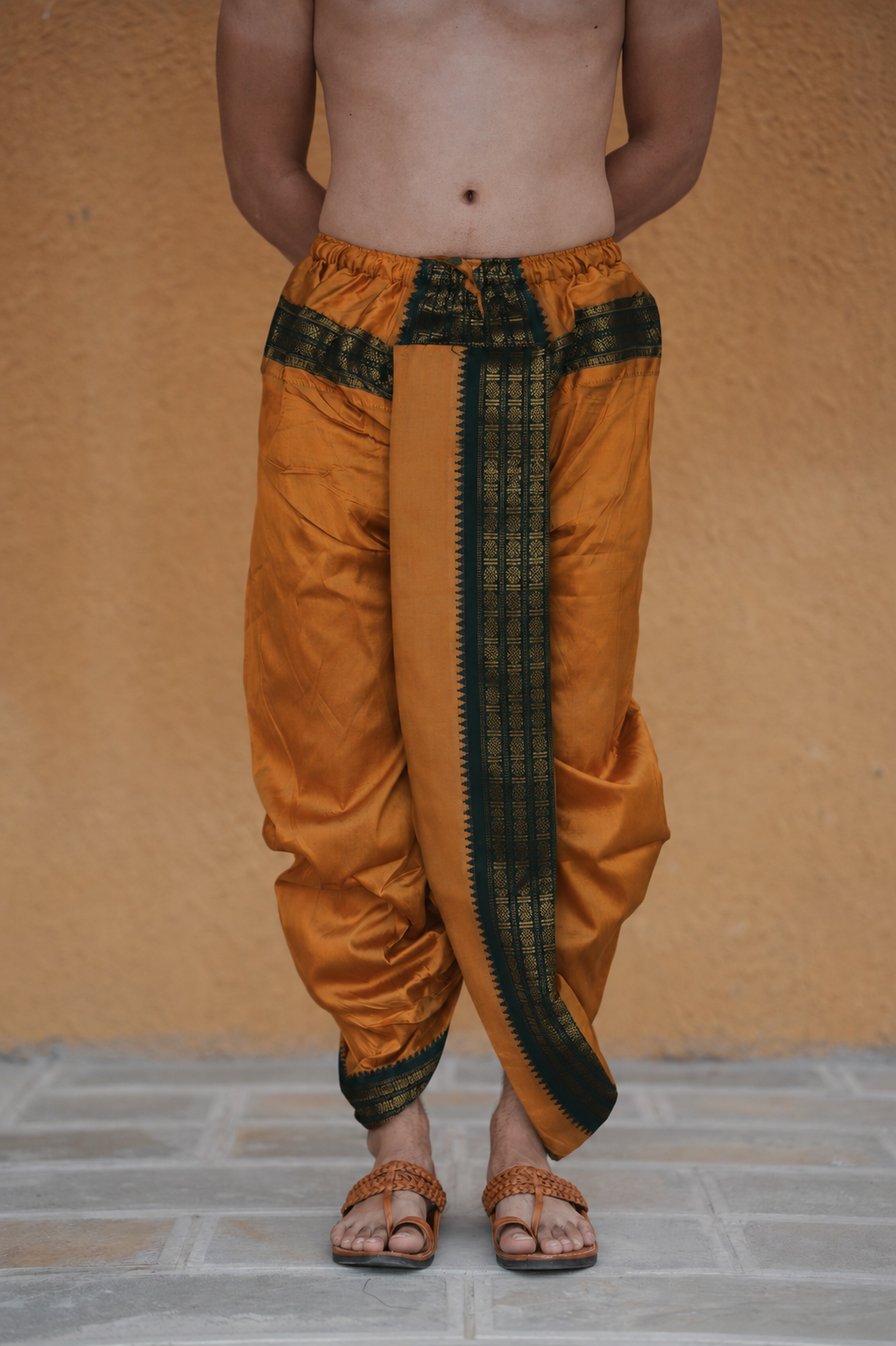 Man wearing a black and gold border readymade brown dhoti