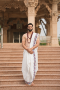 Man wearing a blue and red design border cotton dhoti with uparana