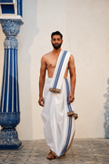 Man wearing a blue border white cotton dhoti with khes