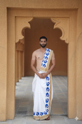 Man wearing a blue peacock border white cotton dhoti with khes