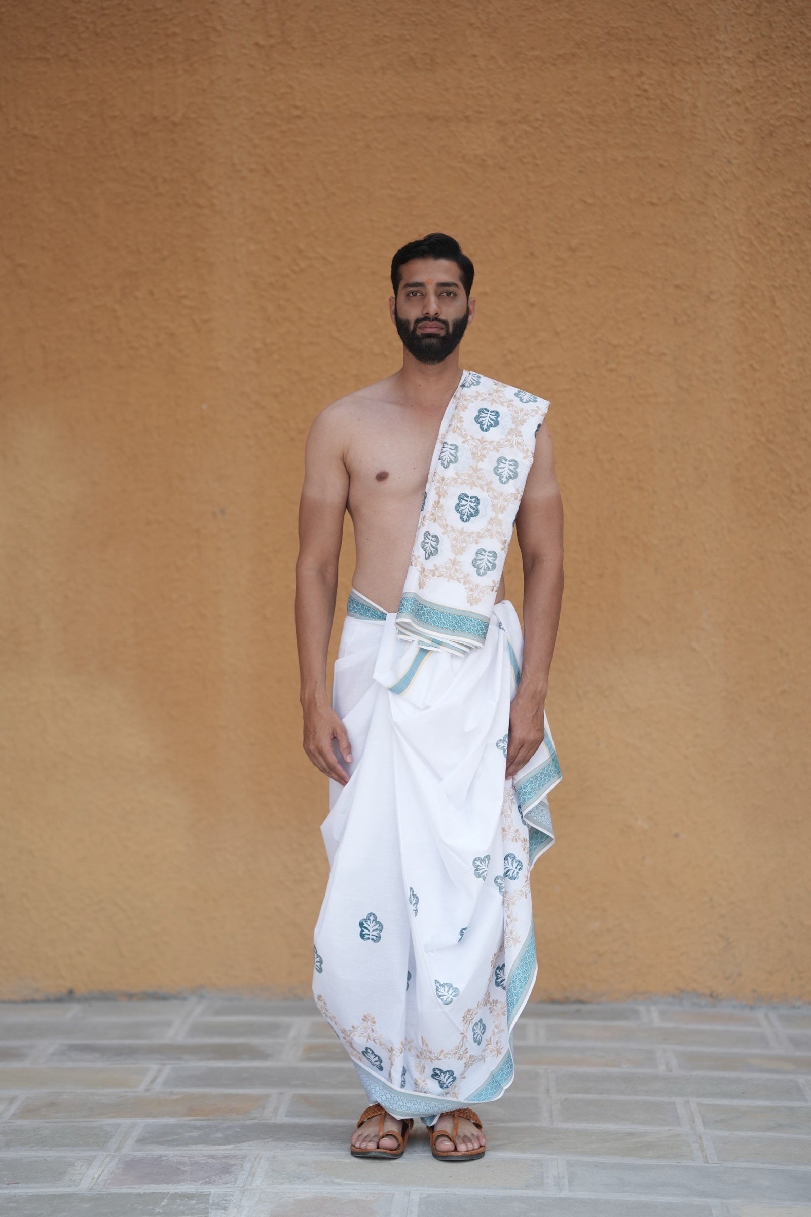 Man wearing a embroidery leaf motif aqua border white cotton dhoti with matching uparana