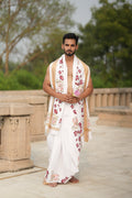 Man wearing a floral and cow border white cotton dhoti with matching uparana