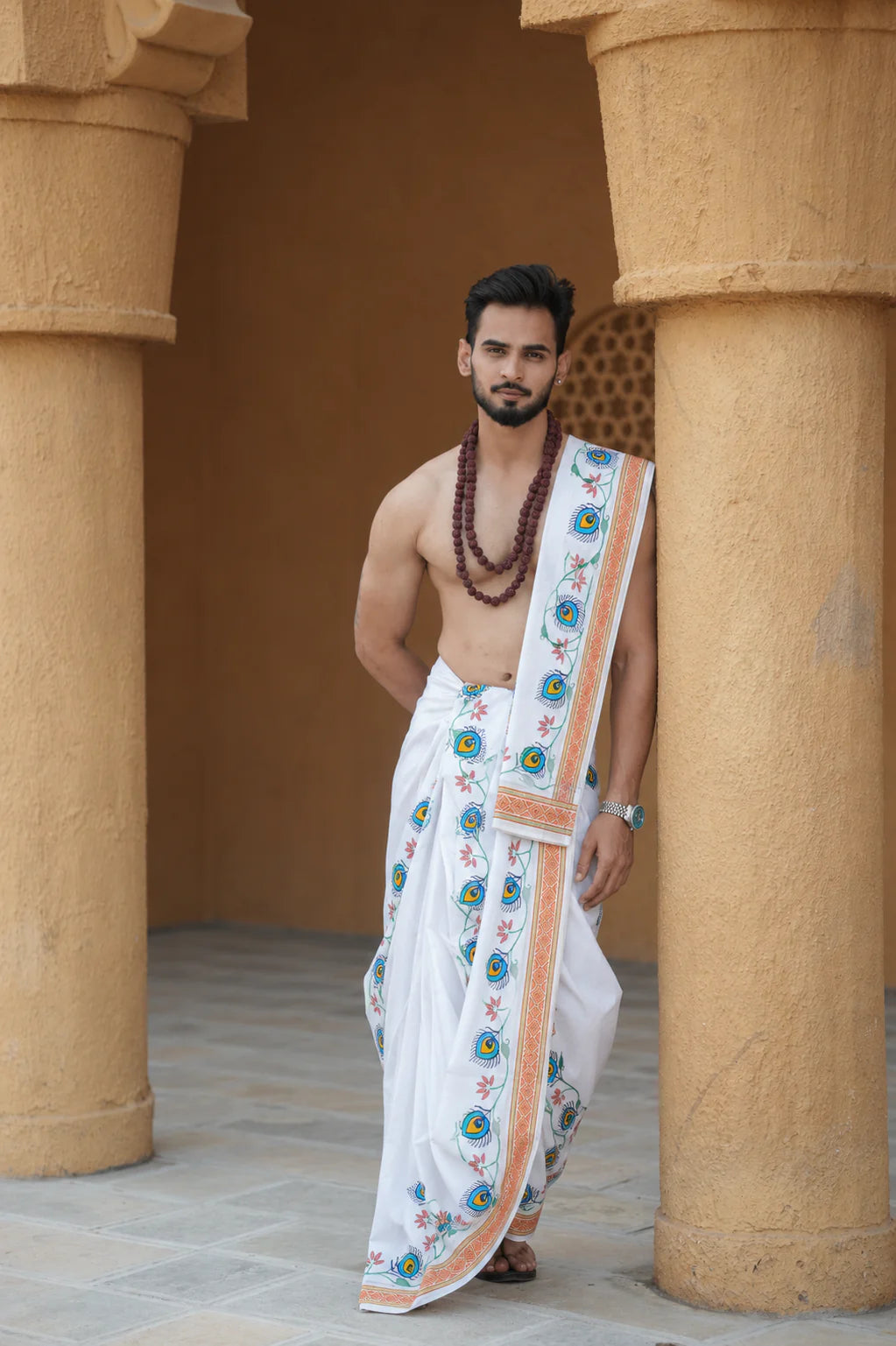 Man wearing a floral and peacock feather border white cotton dhoti with khes