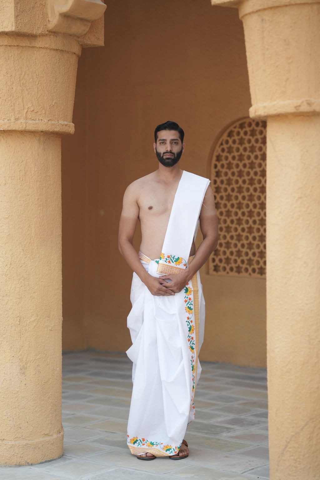Man wearing a floral border white cotton dhoti with gamcha