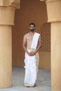 Man wearing a floral border white cotton dhoti with gamcha