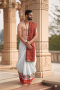 Man wearing a flower and peacock feather border cotton dhoti with khes
