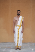 Man wearing a golden zari border white cotton dhoti with matching uparana