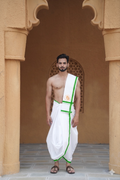 Man wearing a green bordered white cotton dhoti with uparana