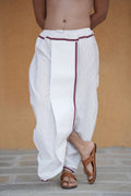 Man wearing a half inch maroon border white readymade dhoti