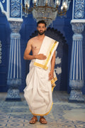 Man wearing a kasavu gold border white cotton dhoti with matching khes