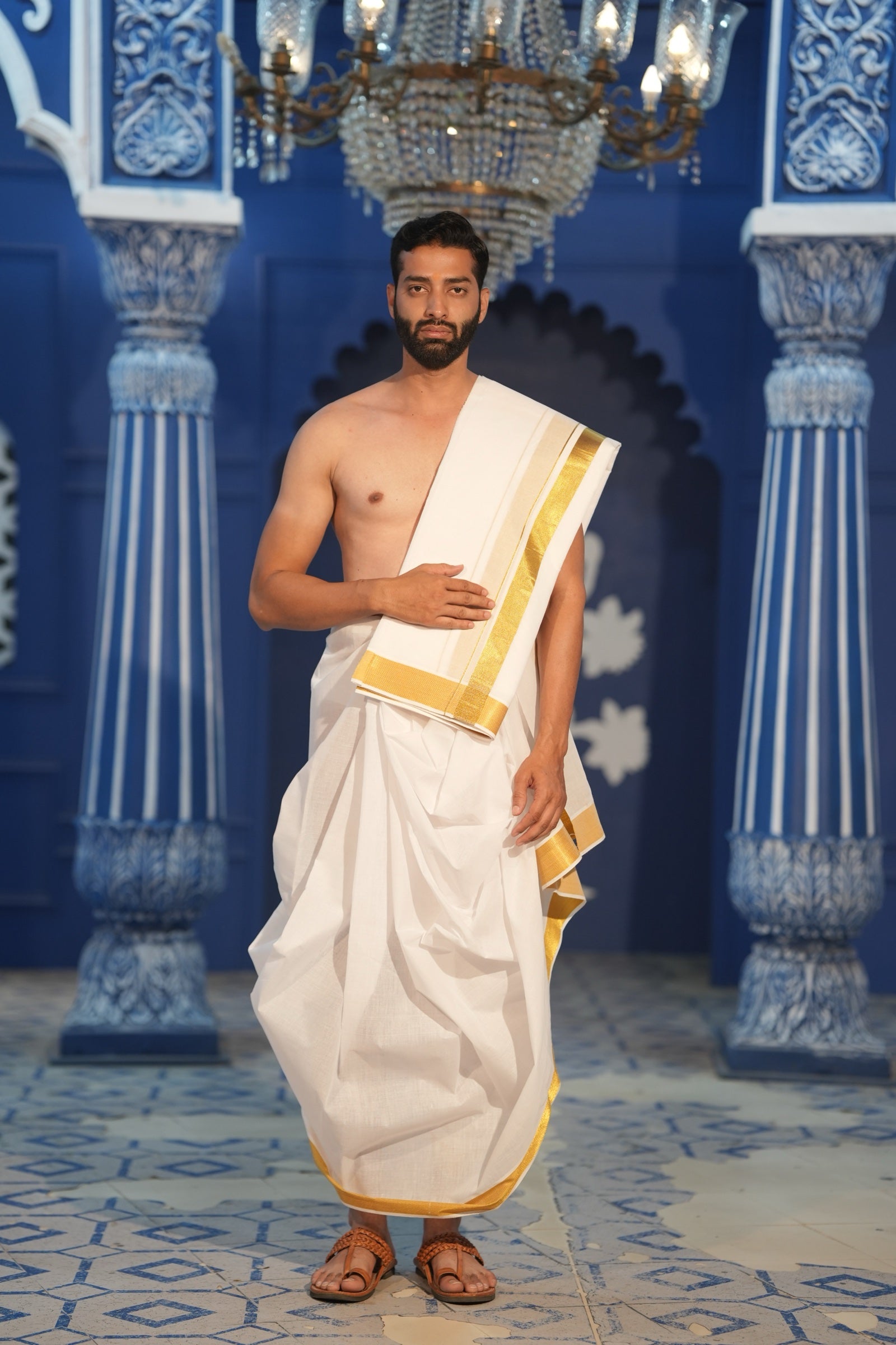 Man wearing a kasavu gold border white cotton dhoti with matching khes