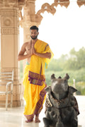 Man wearing a luxurious koral golden jacquard border yellow pure silk dhoti with angavastram 