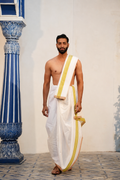 Man wearing a mahendi border white cotton dhoti with matching uparana