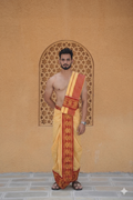 Man wearing a maroon jacquard temple border yellow dhoti with khes
