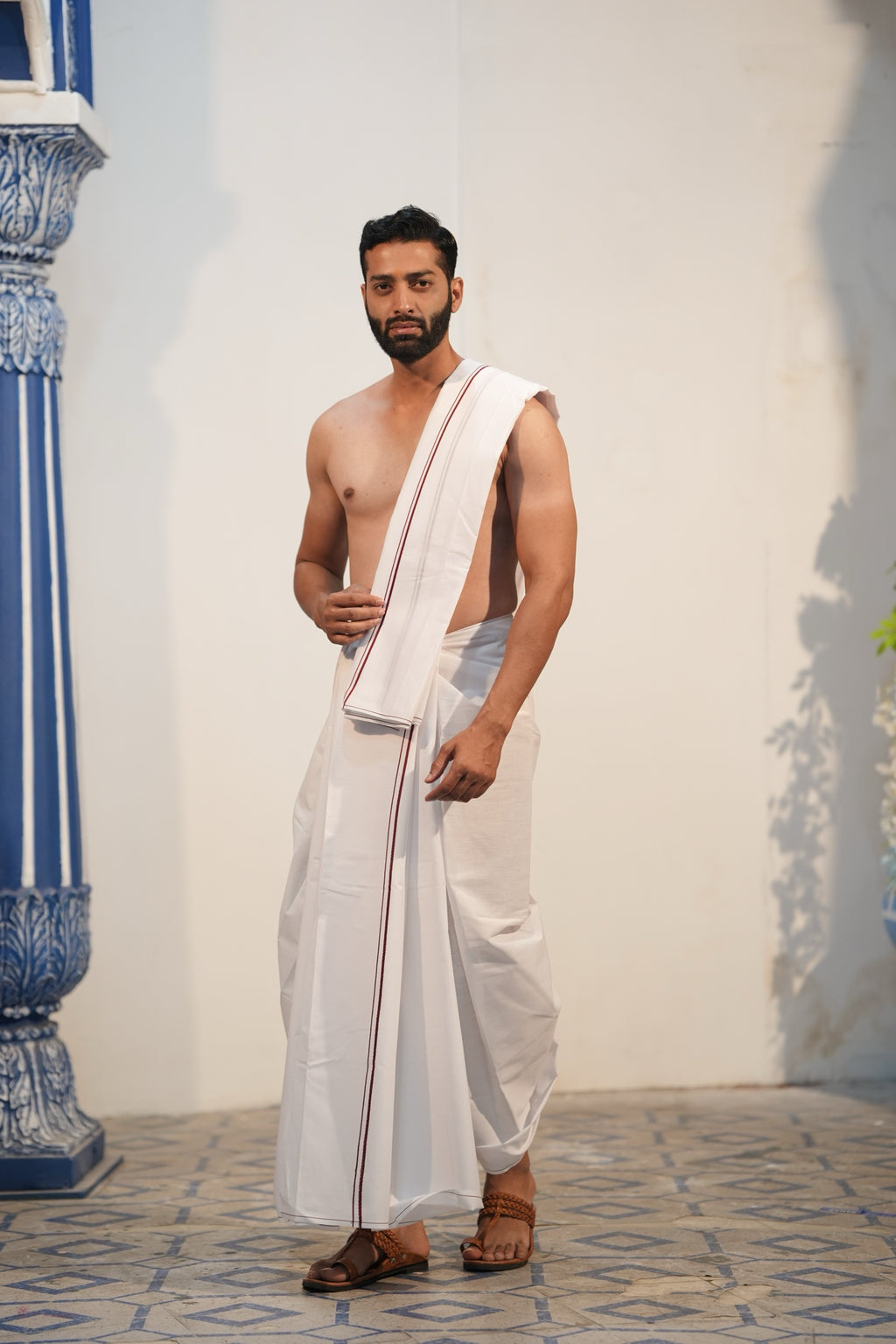 Man wearing a minister style maroon border white cotton dhoti with matching uparana