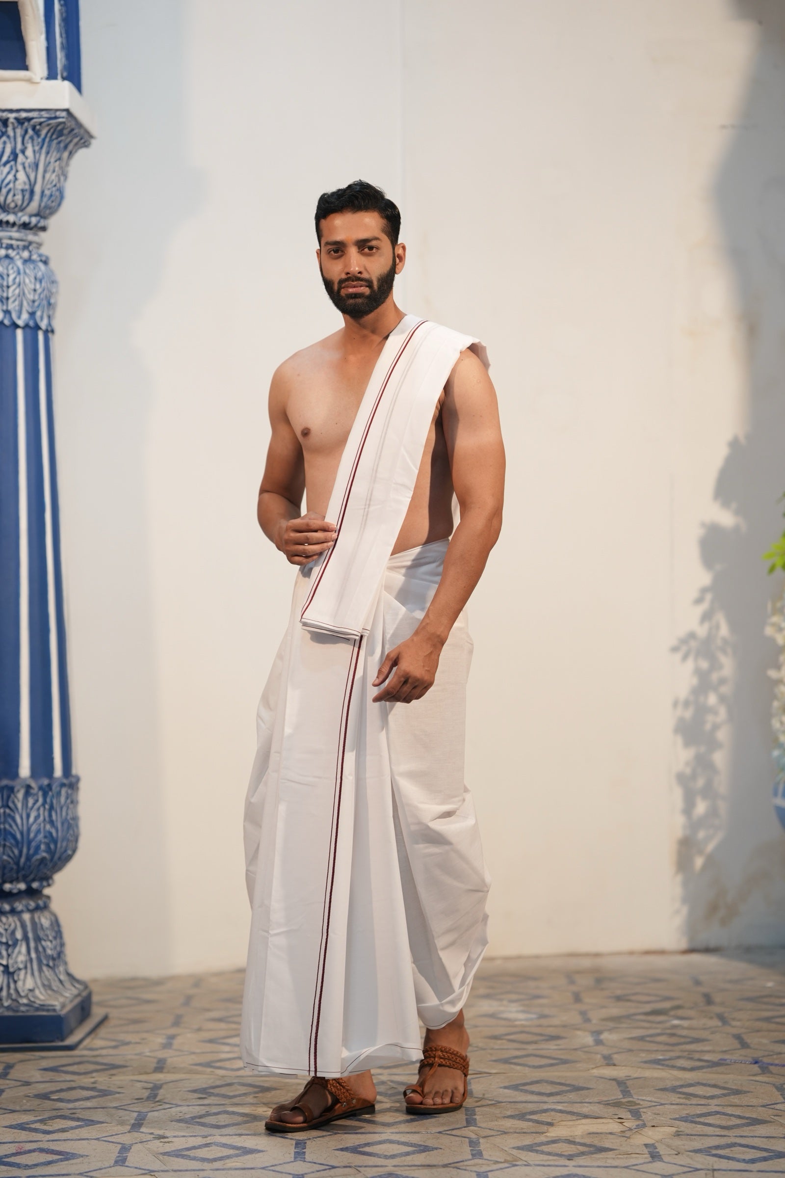 Man wearing a minister style maroon border white cotton dhoti with matching uparana
