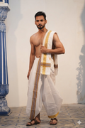 Man wearing a mustard gold fine border white cotton dhoti with khes