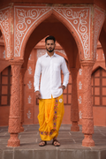 Man wearing a peacock feather design border dhoti and shirt combo
