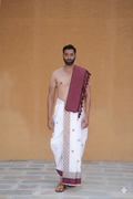 A man wearing a premium marron golden star & floral bordered dhoti with gamchha