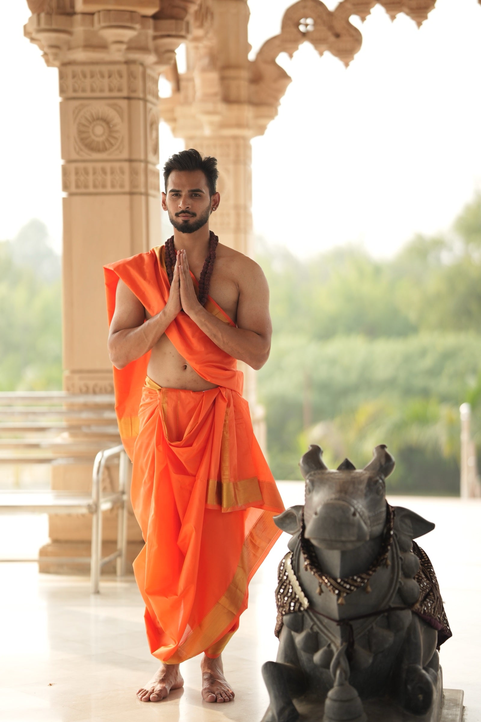 Man wearing a premium golden zari border pure silk orange dhoti with matching uparana