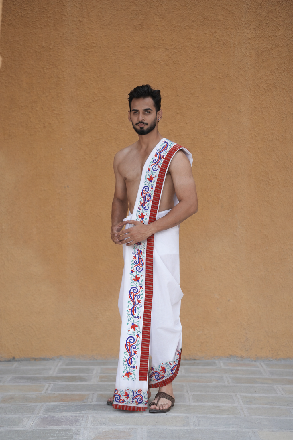 Man wearing a red artistic peacock border white cotton dhoti with khes