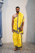 Man wearing a sunlit yellow silk dhoti with uparana