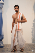 Man wearing a terracotta orange stripe & multicolour border white cotton dhoti with uparana