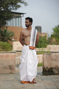 Man wearing a traditional ganga jamuna border white cotton dhoti with matching khes