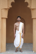 Man wearing a stylish yellow plain bordered white cotton dhoti with uparana